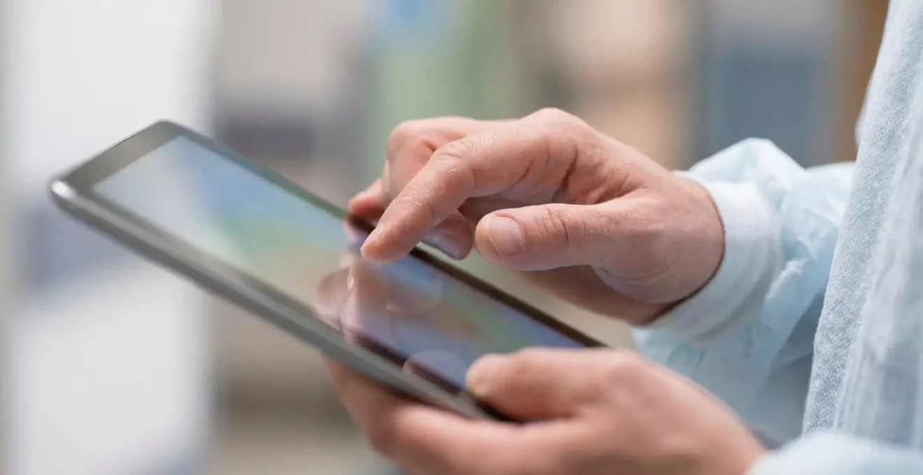 Patient utilisant une tablette dans son lit d'hôpital